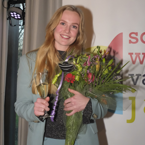 Genomineerde Jojanne van Elderen krijgt bloemen tijdens de uitreiking Sociaal Werker van het Jaar 2025