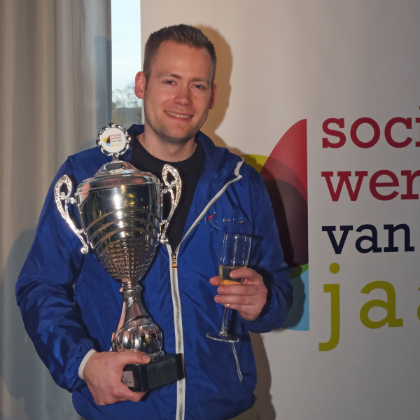 Genomineerde Michel Weening krijgt bloemen tijdens de uitreiking Sociaal Werker van het Jaar 2025