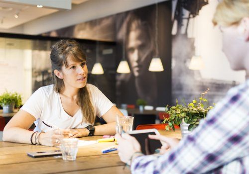 Leidinggevende en medewerker in gesprek over werkbeleving