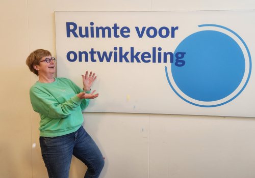 Janny Blom poseert voor bord met tekst ruimte voor ontwikkeling