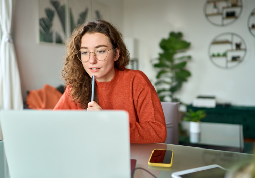 dame kijkt geïnteresseerd naar laptopscherm