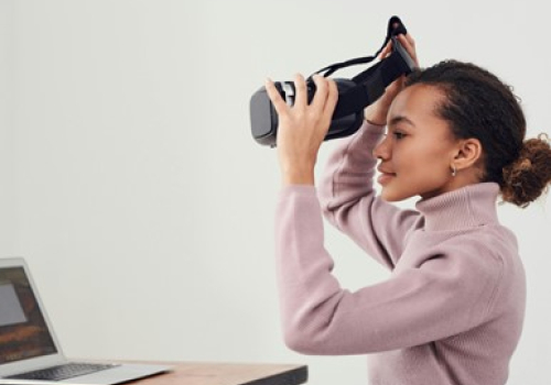 Vrouw achter laptop met vr-bril