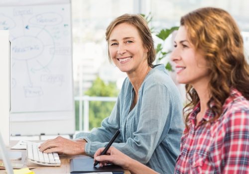 Twee vrouwelijke sociaal werkers achter de pc