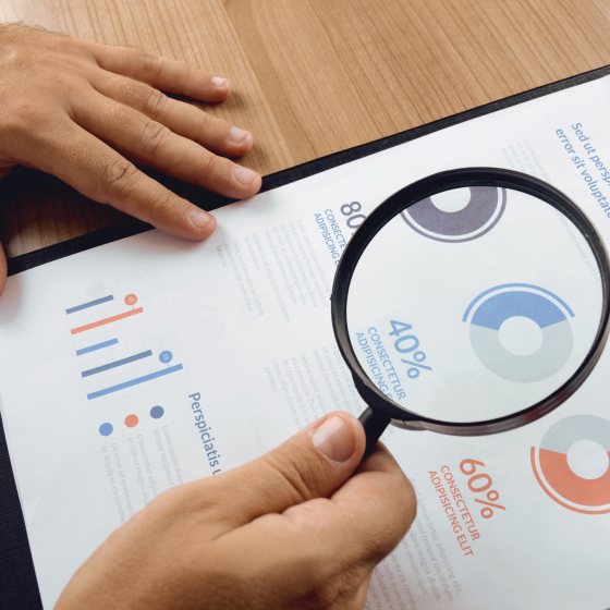 Medewerker bekijkt analyse met vergrootglas