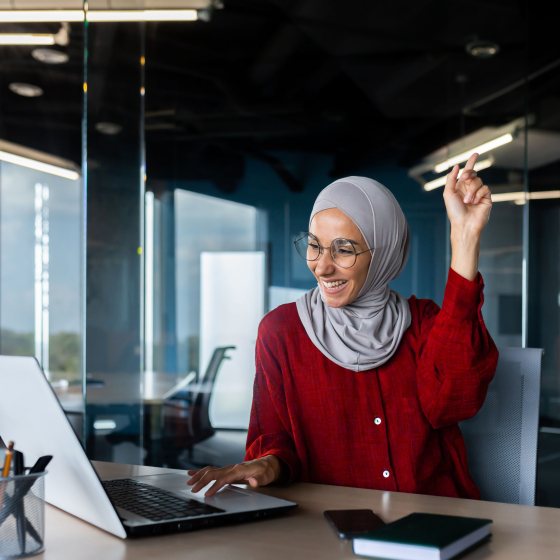 Vrouw achter laptop bekijkt functieboek sociaal werk