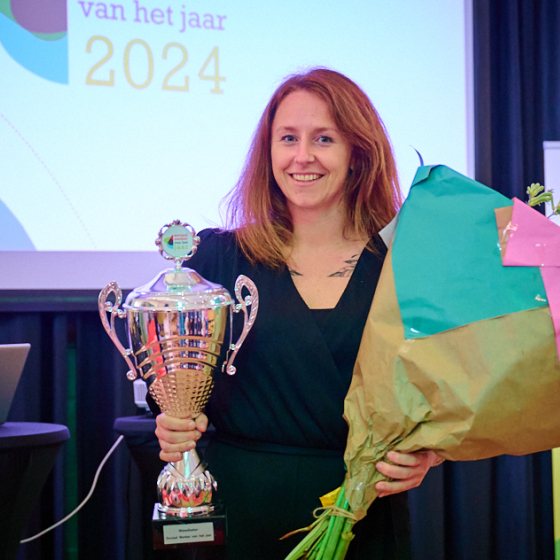 Winnaar Katie Eppenhof poseert met beker en bloemen