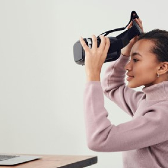 Vrouw achter laptop met vr-bril