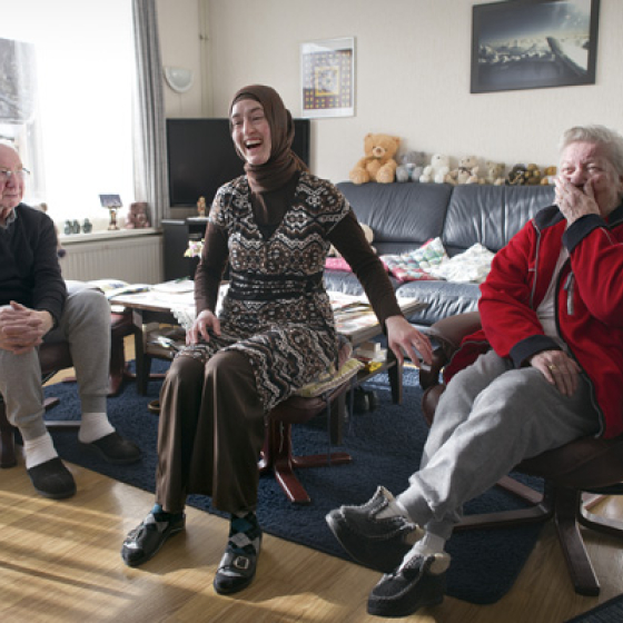 Foto uit expo - Sociaal werker met cliënten lachend op de bank